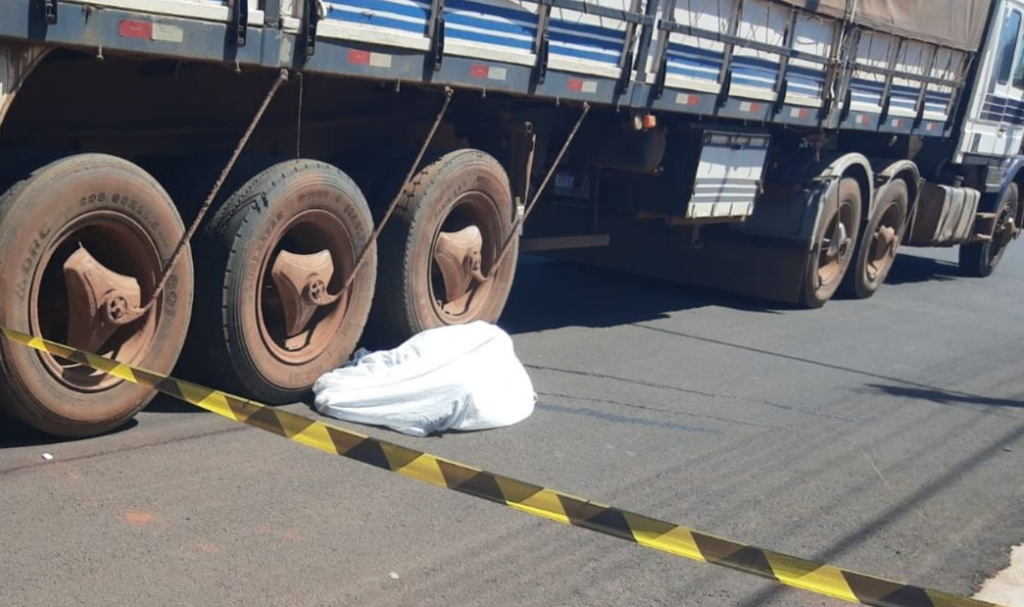 Motociclista atravessa preferencial, bate em carreta e morre atropelado