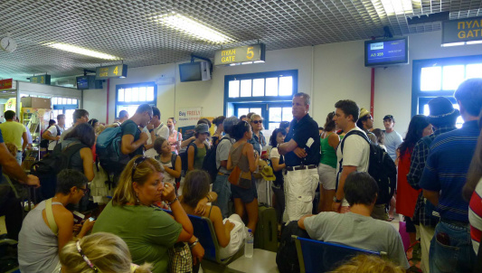 Os 10 piores aeroportos do mundo Passageiros esperando em frente às portas de embarque no aeroporto de Santorini. P. R. C