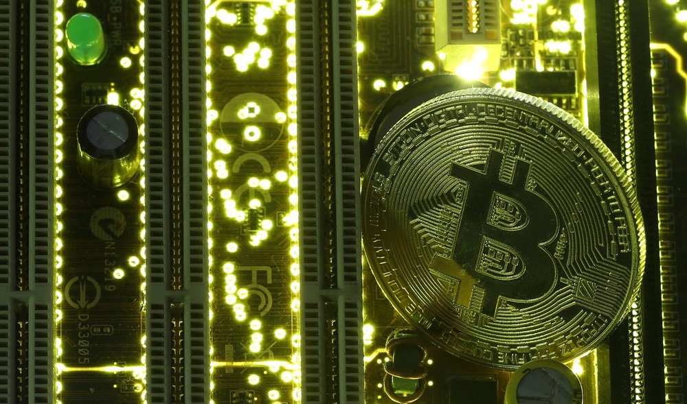 Moeda ilustrativa do bitcoin, em meio a placa-mãe de computador. (Foto: Dado Ruvic/Reuters)