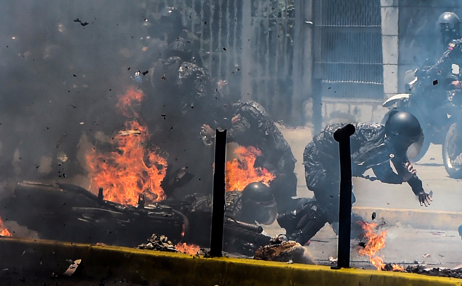 Itamaraty condena violência na Venezuela e pede que autoridades suspendam Constituinte Policiais se afastam do fogo após explosão de motos em protesto na Venezuela (Foto: Juan Barreto/AFP)