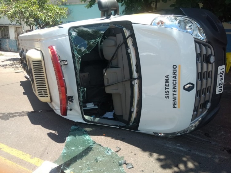 Viatura da Agepen tomba depois de ser atingida por caminhão Van da Agepen tombou no impacto e atingiu um carro e uma moto que estavam estacionados. Agetrat/Divulgação