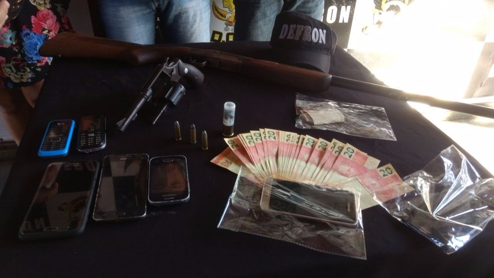 Armas, dinheiro e celulares apreendidos na casa da mulher suspeita de participar de assalto (Foto: Defron/Divulgação)