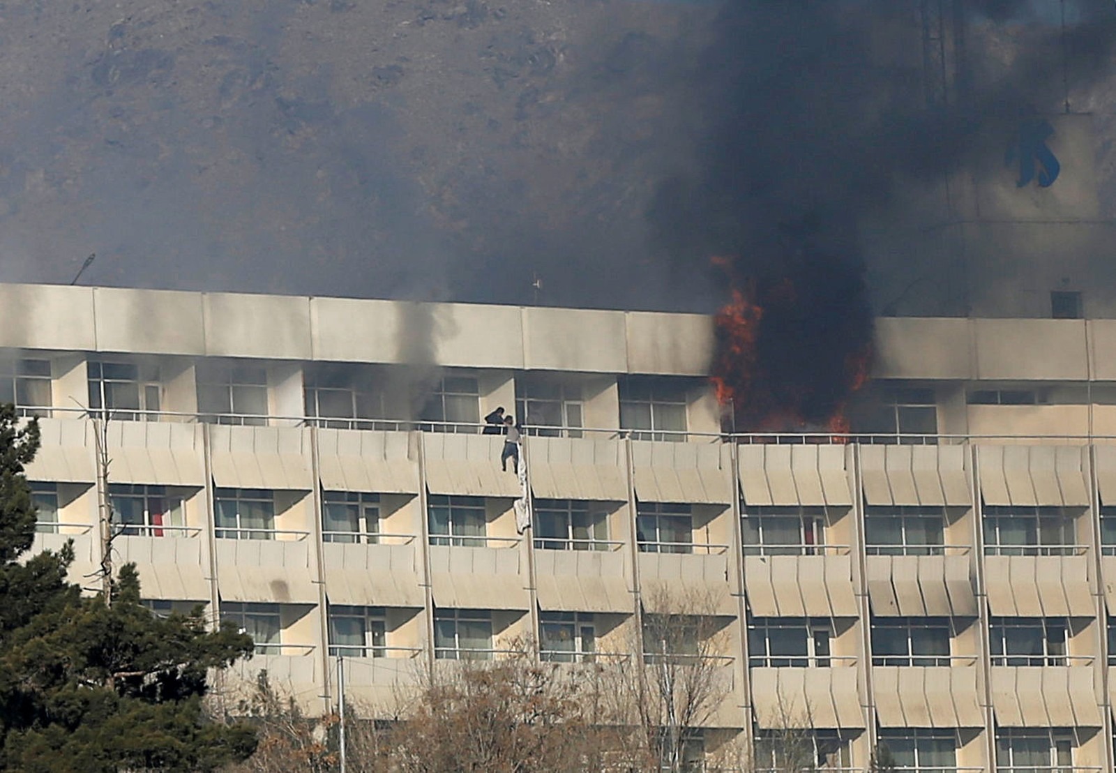 Homem tenta escapar de ataque pela sacada de quarto no Hotel Intercontinental de Cabul, no Afeganistão (Foto: Omar Sobhani/Reuters)