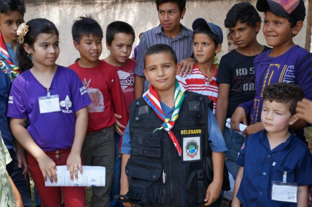 Criança, junto com os colegas, posa para foto com o colete a prova de balas do delegado. (Foto: reprodução/Facebook)