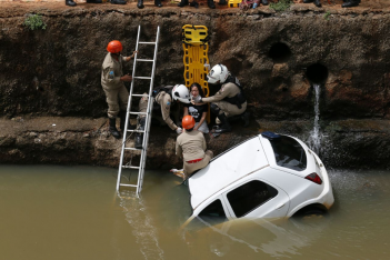 Condutora de Celta capota e cai no córrego Prosa na Capital Foto Cleber Gellio