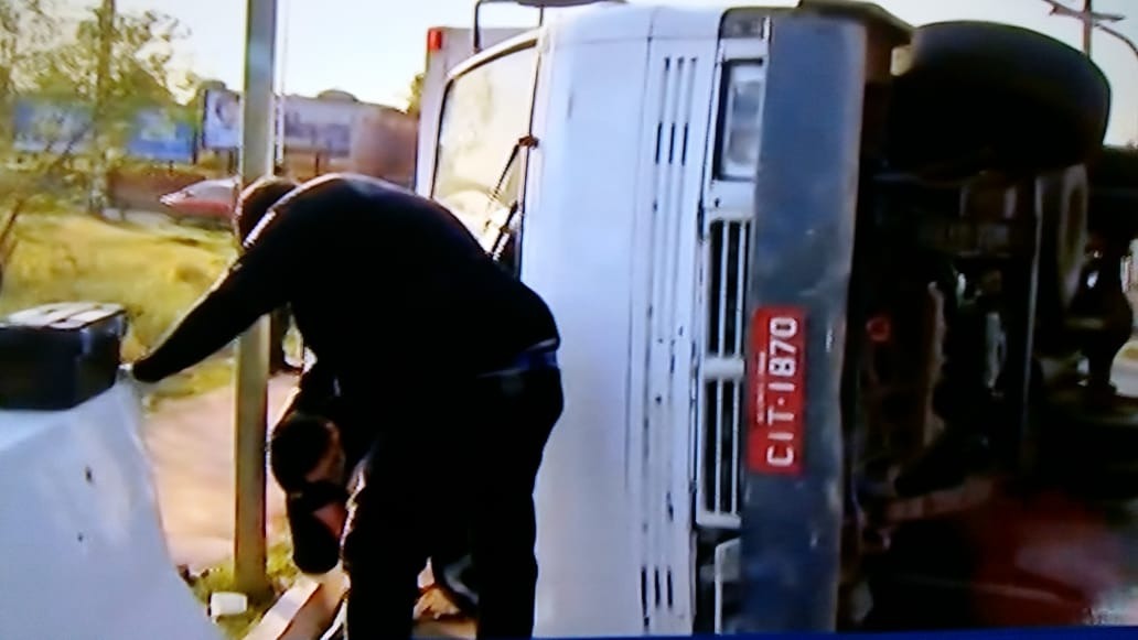 Agentes realizando a perícia no veículo tombado.