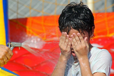 Menina se molha para refrescar na Capital (Foto: Marcos Ermínio)