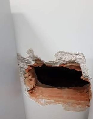 Buraco feito na parede dos fundos da agência.