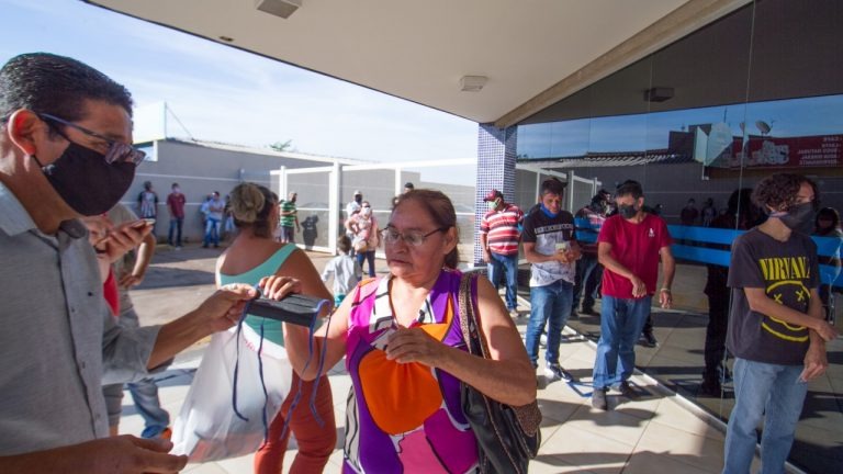 Prefeitura entrega máscaras a população em fila para saque de auxílio emergencial Diogo Gonçalves