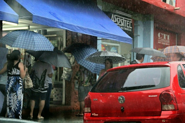 No centro, pedestres driblam instabilidade com guarda-chuvas. (Foto: Marcos Ermínio)
