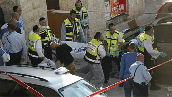 Netanyahu promete 'pulso firme' após ataque a sinagoga em Jerusalém Voluntários do serviço de emergência israelense carregam corpo de palestino acusado pelo ataque