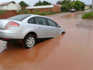 Carro foi engolido por buraco dentro da enxurrada. (Foto: Benê Soares)