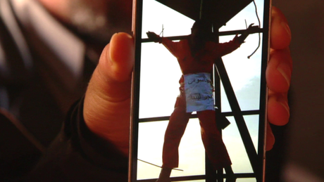 Líbio mostra no celular imagem de seu irmão, que teria sido morto a tiros e crucificado pelo EI
Foto: BBC / BBCBrasil.com
