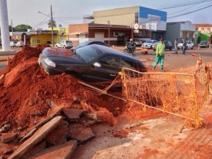 Motorista cai com carro dentro de buraco feito por obras na Bandeirantes (Foto: Henrique Kawaminami)