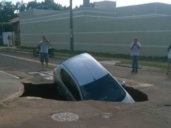 Praticamente o carro todo está no buraco. (Foto: Cleber Martins Ferreira)