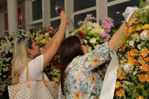 Mulheres arrumam homenagens ao advogado.