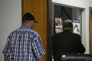 Técnico agrícola, de boné, chegou acompanhado do advogado para se apresentar à polícia na 2ª DP. (Foto: Marcos Ermínio