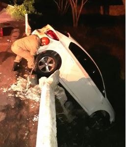 Motorista bate em mureta e carro fica pendurado Motorista bate em mureta e carro fica pendurado