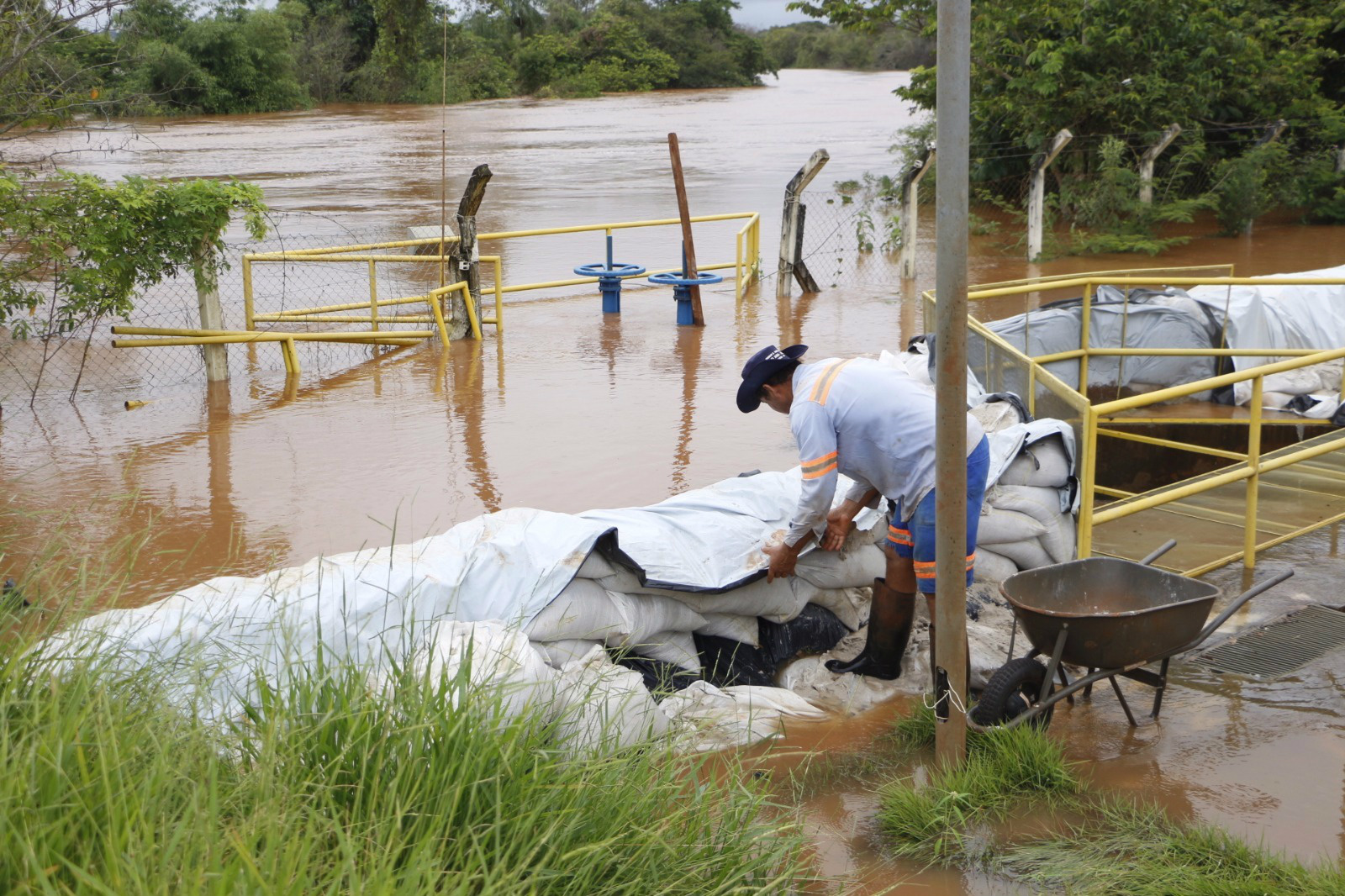 Rio Dourados está cheio mas não compromete abastecimento Funcionários da Sanesul, fazem barricada para impedir que água entre na estação de tratamento(Foto: Eliel Oliveira)