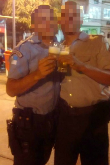 Vestindo suas fardas, dois homens brindam com a cerveja Foto: Reprodução