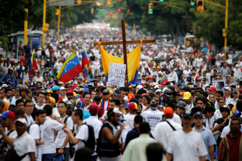 Manifestantes vestidos de branco tomaram as ruas de Caracas, a capital da Venezuela, para protestar contra o governo do presidente Nicolas Maduro e para lembrar as vítimas da violência dos últimos dias. (Foto: Carlos Garcia Rawlins/Reuters)
