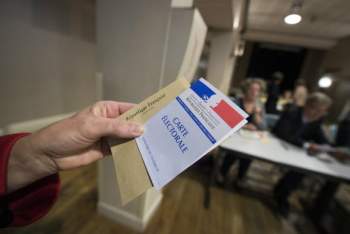 Eleitor mostra cédula de votação para eleição presidencial na França neste domingo Caroline Blumberg/EPA/Lusa/Direitos Reservados 