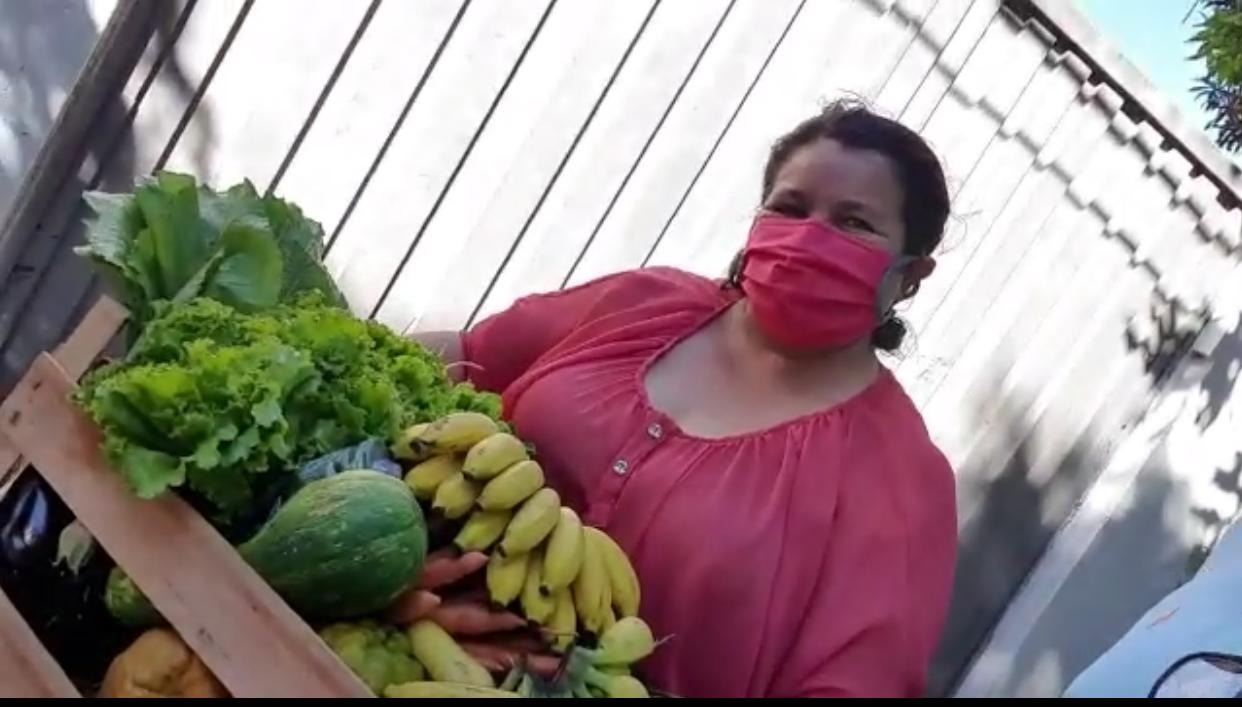 Dona Maria de Brito entregando verduras na porta da residência do senador Nelsinho Trad