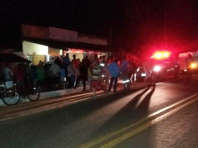 Homem é morto com golpe de faca nas costas em bar Moradores no bar, após o crime. (Foto: Glória News)