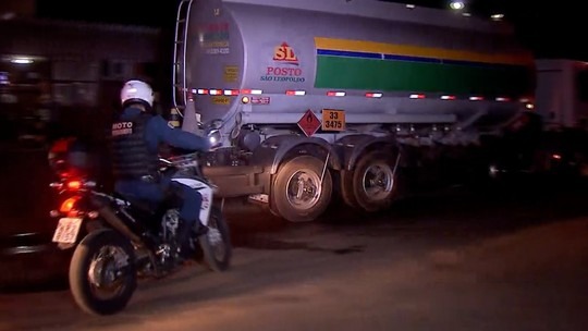 Carretas saem de distribuidora de Campo Grande para abastecimento de postos Forças de segurança escoltaram caminhão carregado de combustível em Campo Grande na noite de ontem (26). (Foto: TV Morena)