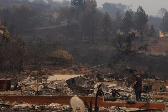 Mulher observa restos de uma casa destruída por incêndios em Napa, na Califórnia Reuters/Jim Urquhart/Direitos Reservados 