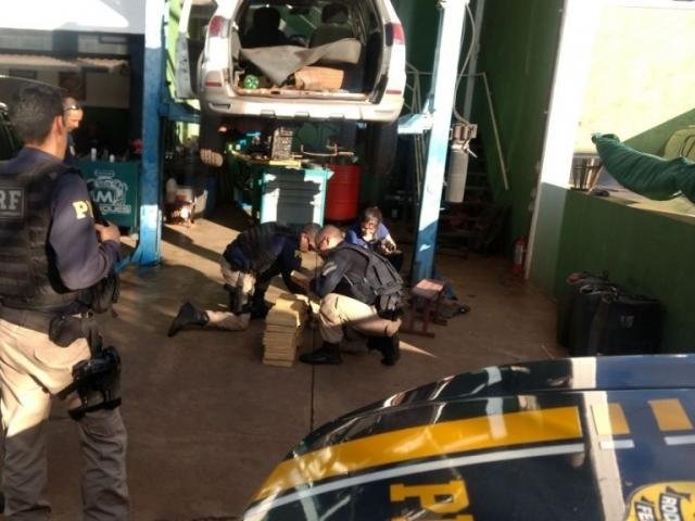 Policiais rodoviários federais analisando droga apreendida (Foto: Divulgação/PRF)