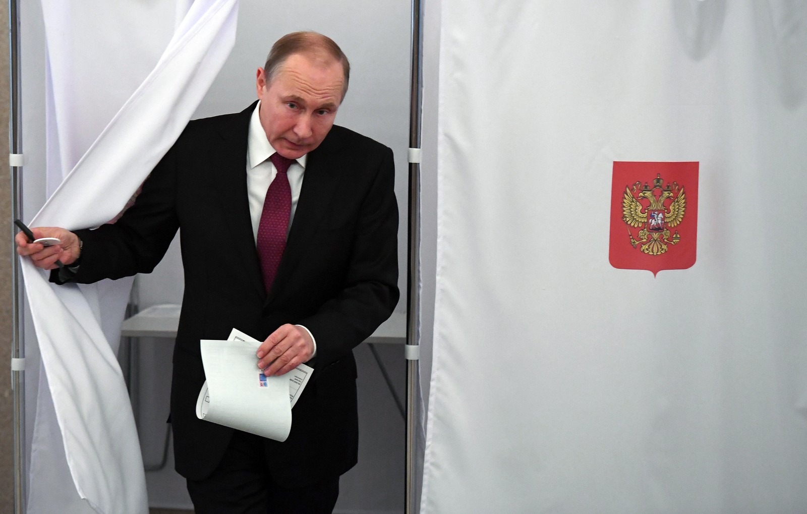 O presidente Vladimir Putin deixa cabine de votação durante eleições na Rússia, neste domingo (18). (Foto: Yuri KADOBNOV / POOL / AFP)