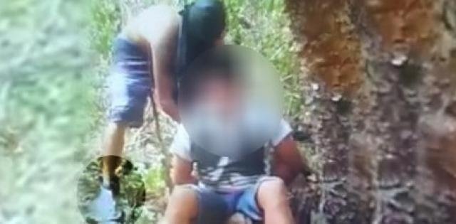 PC divulga identificação de acusados envolvidos em decapitação de jovem em Corumbá Assassino encapuzado que aparece no vídeo, usa tornozeleira eletrônica. Reprodução/vídeo