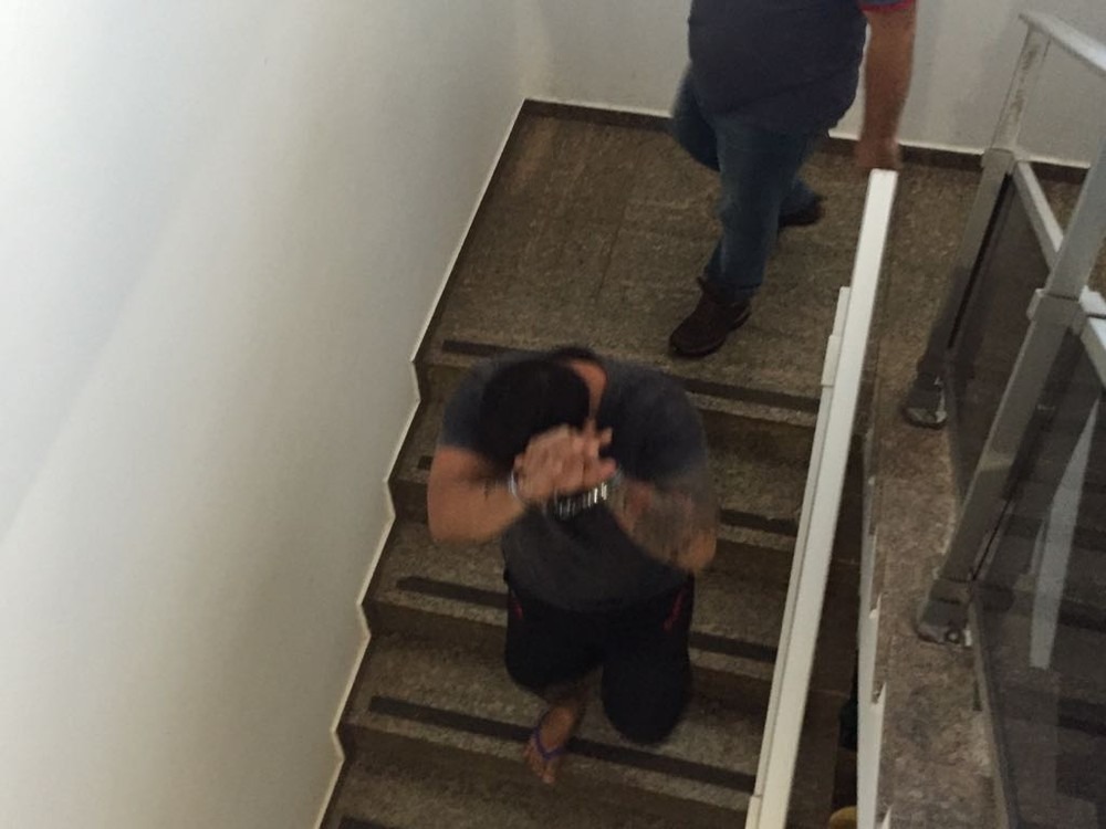 Suspeito sendo levado para outra sala na Delegacia de Proteção à Criança e ao Adolescente (Foto: Dyego Queiroz)