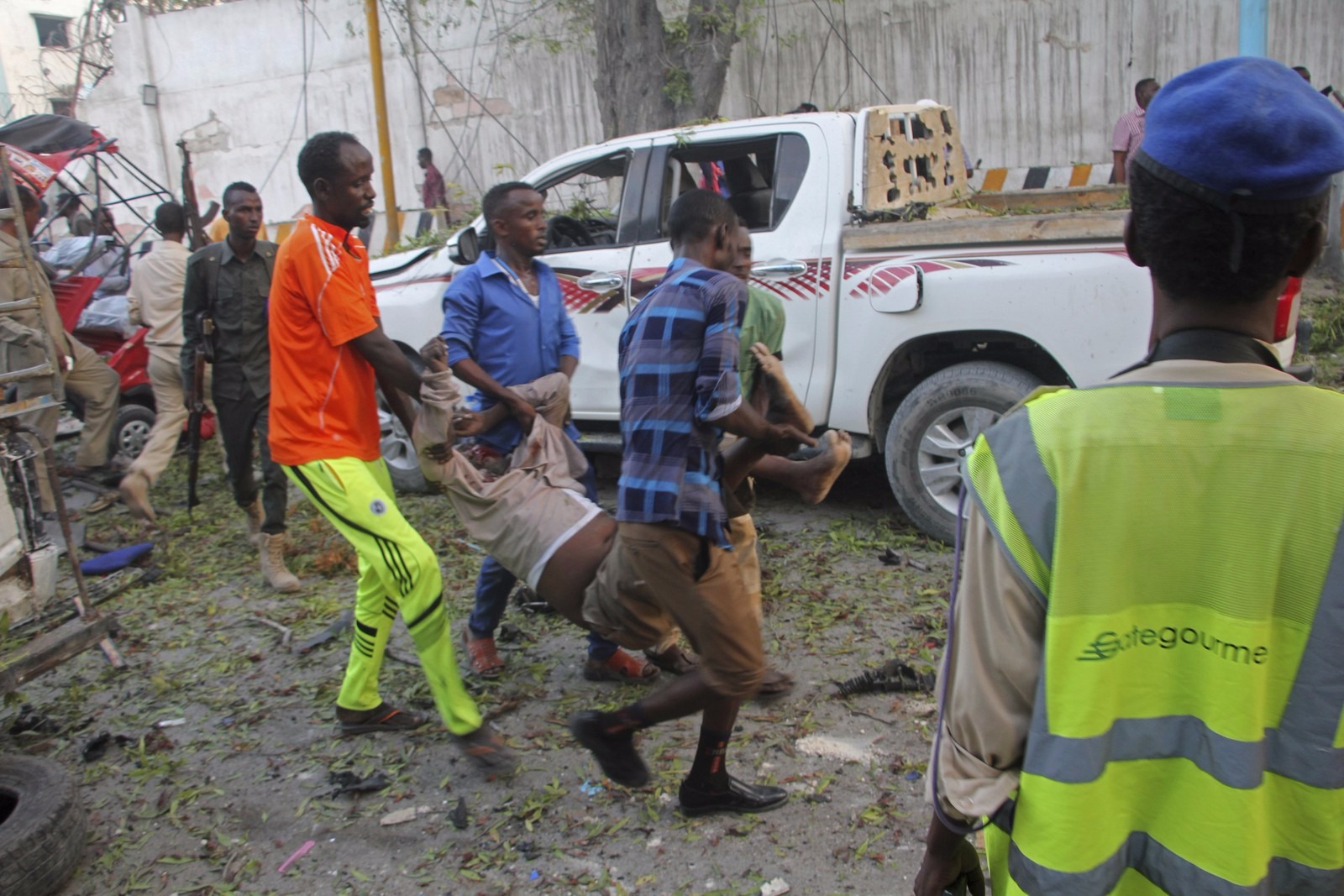 Homens carregam ferido em explosão em Mogadíscio (Foto: AP Photo/Farah Abdi Warsameh)