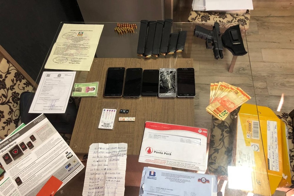 Documentos falsos, arma e celulares apreendidos durante operação. PF/Divulgação