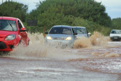 Carros passam por área alagada nesta sexta em Campo Grande (Foto: Marcos Ermínio)