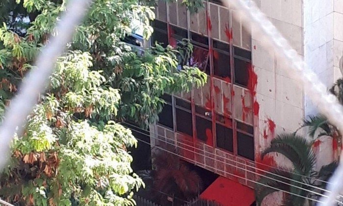 Manifestantes se unem para limpar prédio de Cármen Lúcia que foi atacado Na calçada, manifestantes usavam equipamentos de hidrojateamento para limpar a tinta vermelha. - Foto: Reprodução/O Globo
