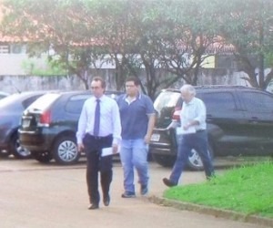 Em depoimento, estudante nega que pai tenha induzido a fugir de acidente Estudante e pai saindo da delegacia com advogado. - Luana Rodrigues