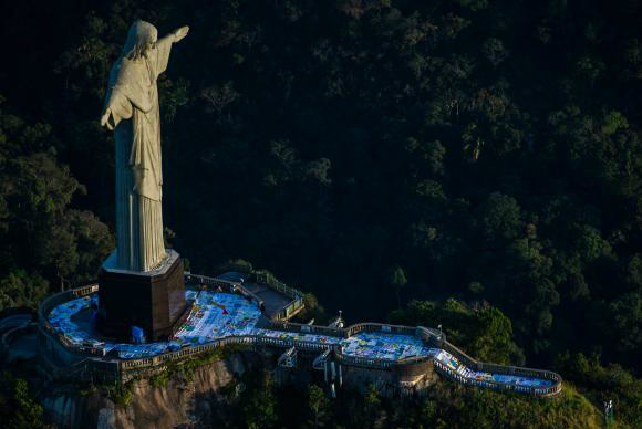 Mosaico gigante de bandeiras pedindo paz é exposto no Cristo Redentor O mosaico é formado por bandeiras feitas por estudantes de todo o país Alex Ferro/Divulgação: Rio 2016