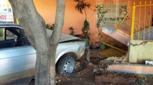 Traficante foge da polícia, perde o controle do veículo e destrói muro O carro bateu no muro, destruindo a frente e o portão da casa (Foto: Divulgação/PC)