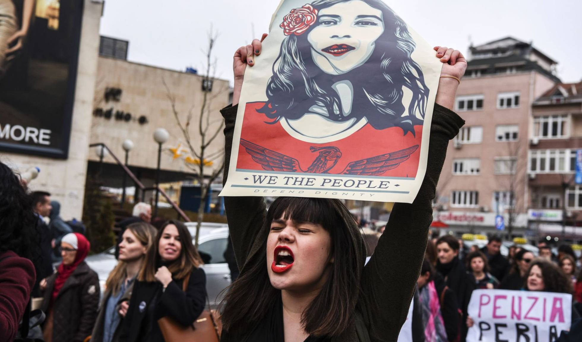 Mulher com um cartaz que diz “Nós, o povo, defendemos a dignidade”, durante manifestação em Kosovo em março. ARMEND NIMANI AFP