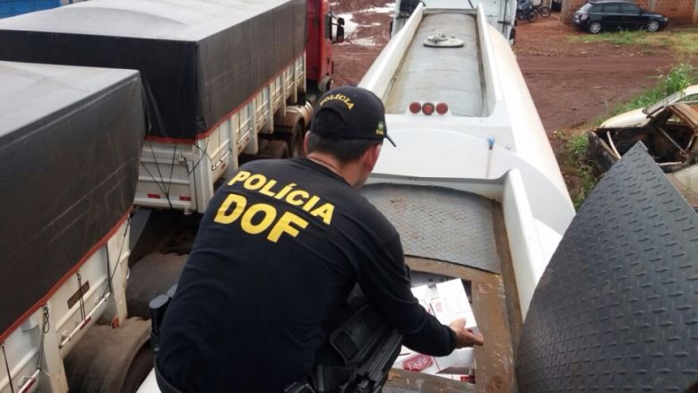 Policial do DOF retira cigarros de dentro de um dos caminhões - Foto: Osvaldo Duarte
