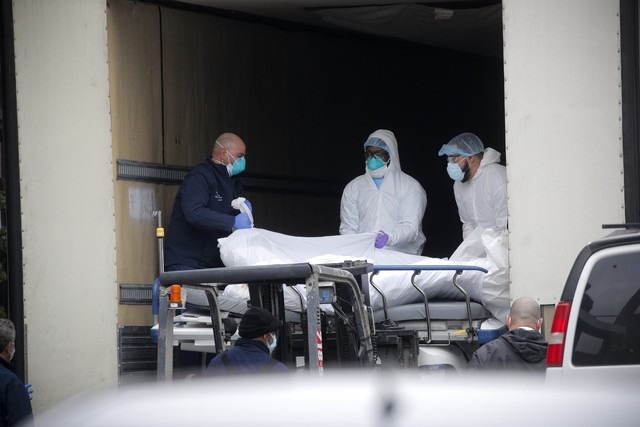 Em Nova York, profissionais de saúde colocam uma vítima de Covid-19 em uma van, em 30 de março de 2020 / Foto: Brendan Mcdermid/Reuters