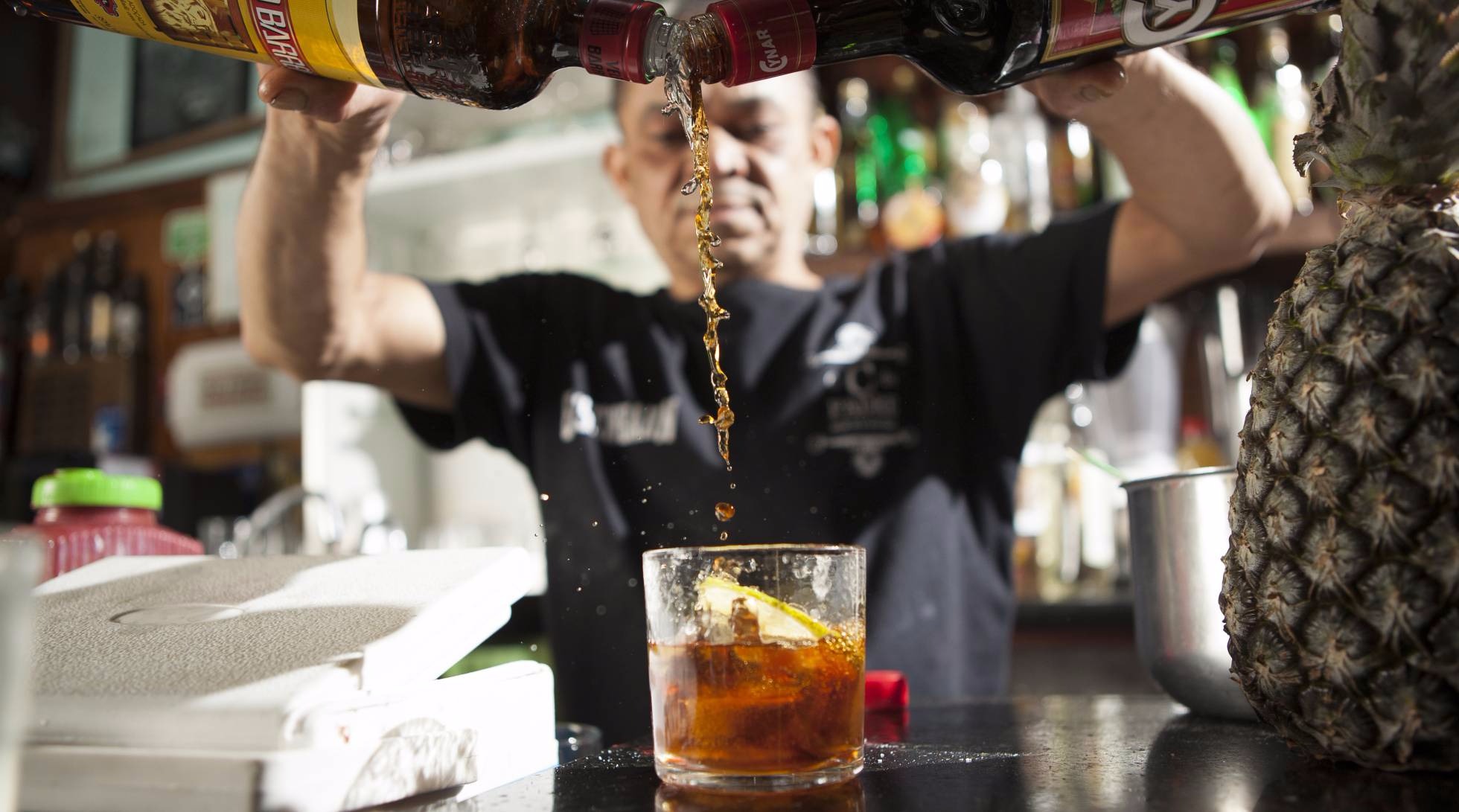 Fera, bartender há 28 anos, prepara um rabo de galo. RAONI MADALENA