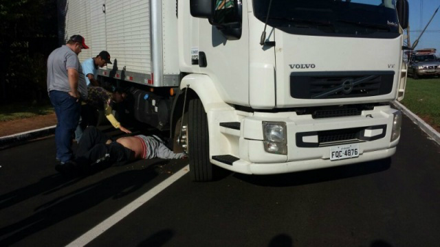 Motociclista tem lesões leves após bater e parar embaixo de caminhão Motociclista parou embaixo de caminhão, mas não teve ferimentos leves (Foto: Rafael Domingos)